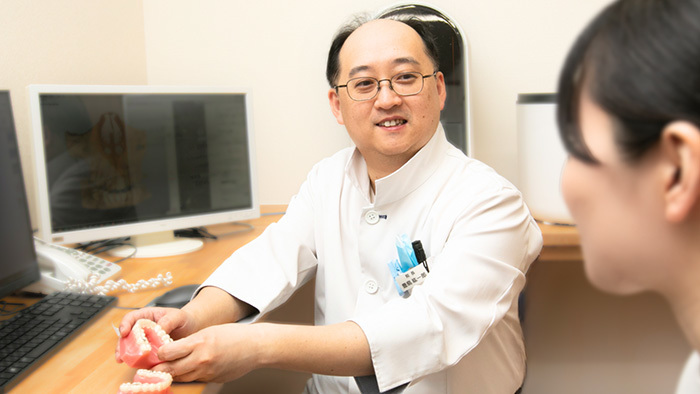 患者の歯並びの悩みをヒアリングしている院長