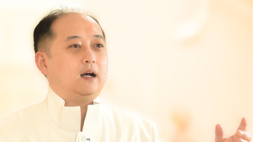 患者に非抜歯矯正の治療計画を説明する院長