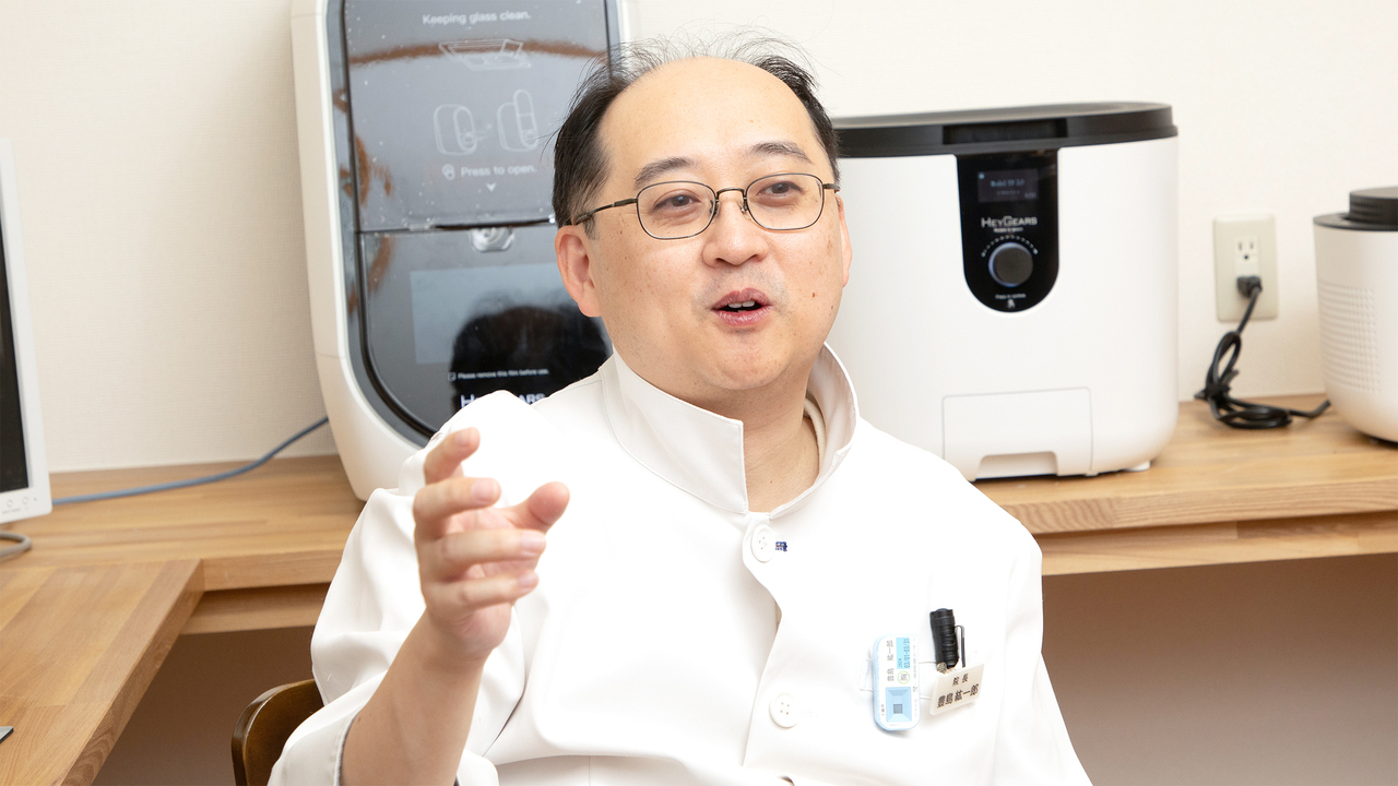 治療にかかる費用や期間が不安な患者に説明を行う院長