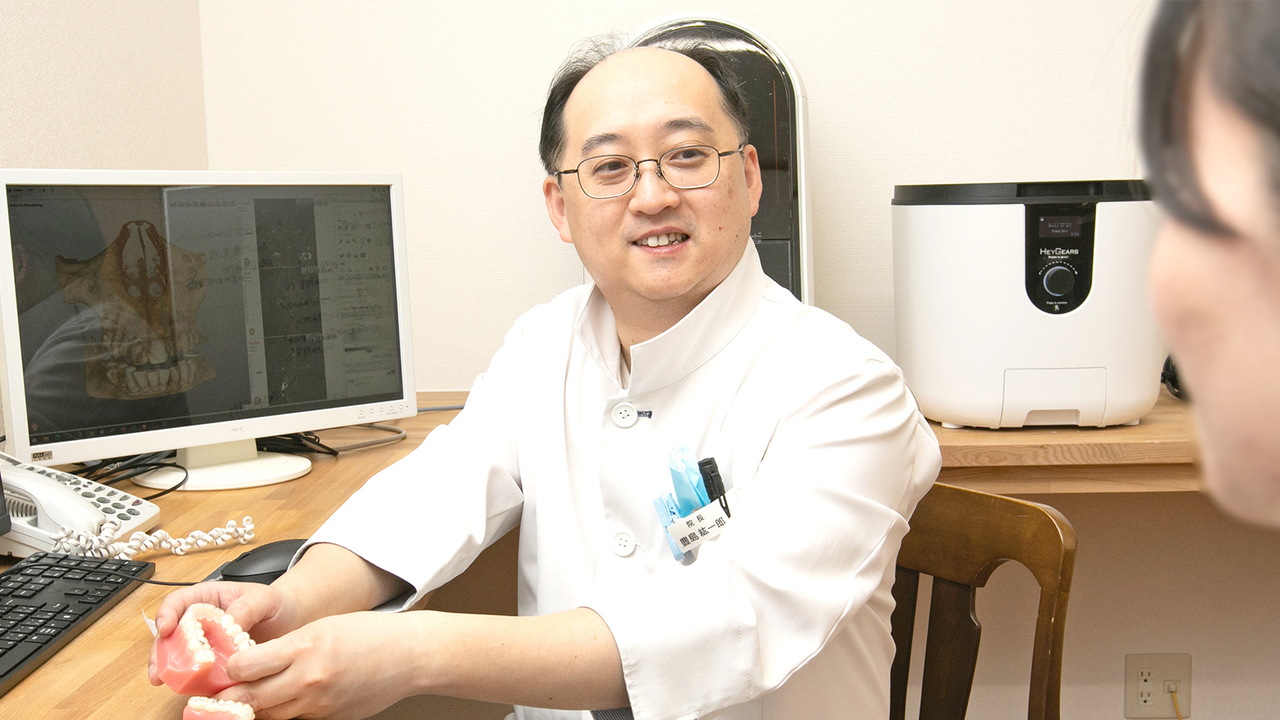 患者の悩みや不安に寄り添いながら会話している院長